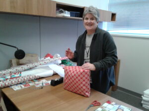 Member of Division of Nephrology wraps Christmas present for Adopt-a-Family event.