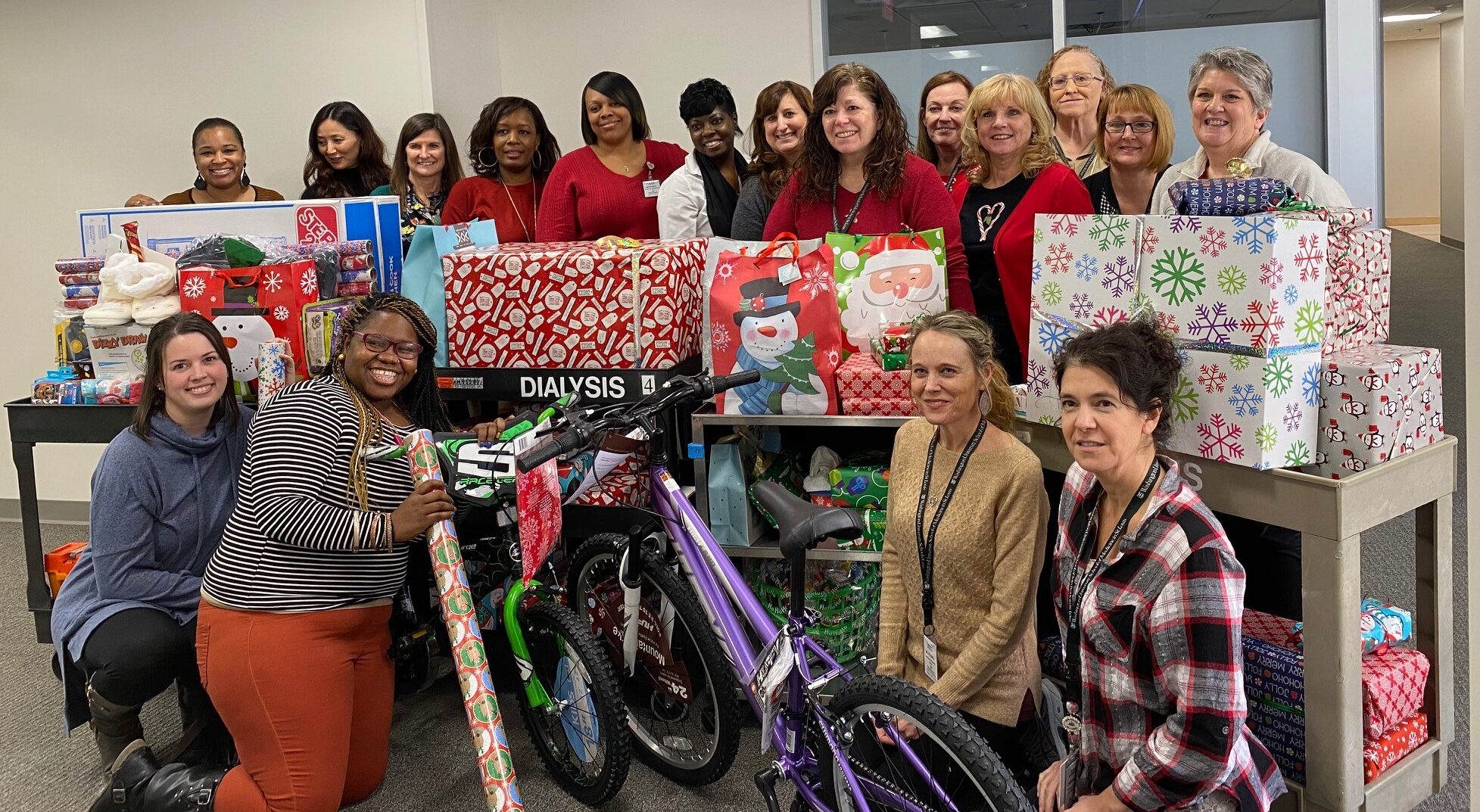 Staff and faculty of Division of Nephrology at Washington University School of Medicine, St. Louis, gather around Christmas gifts to be given to families of three children on dialysis.ift 
